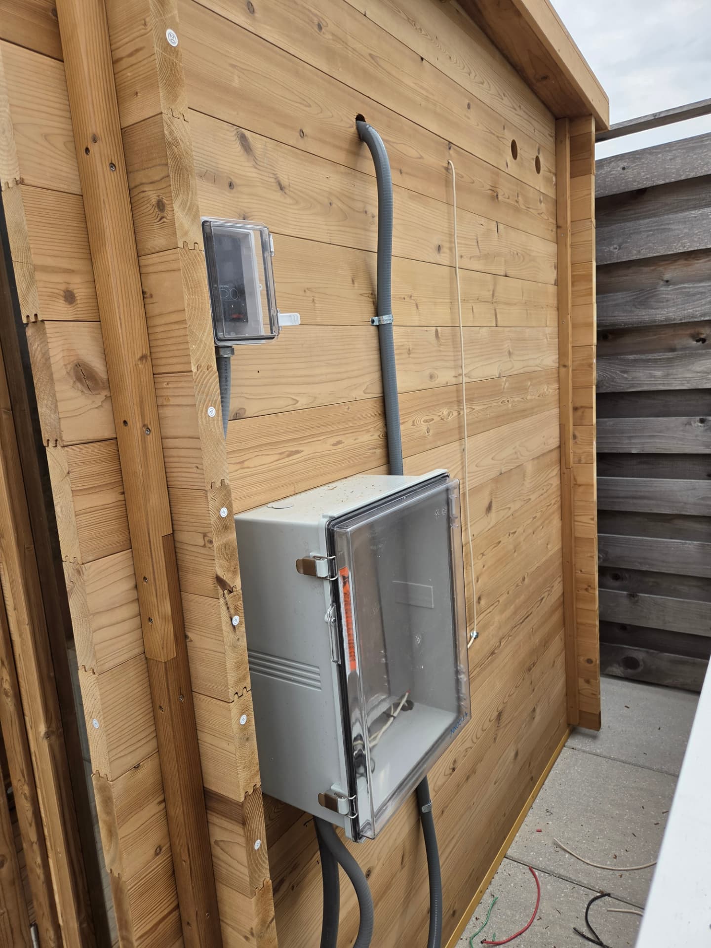 Weatherproof electrical controls and conduit installed for a rooftop sauna