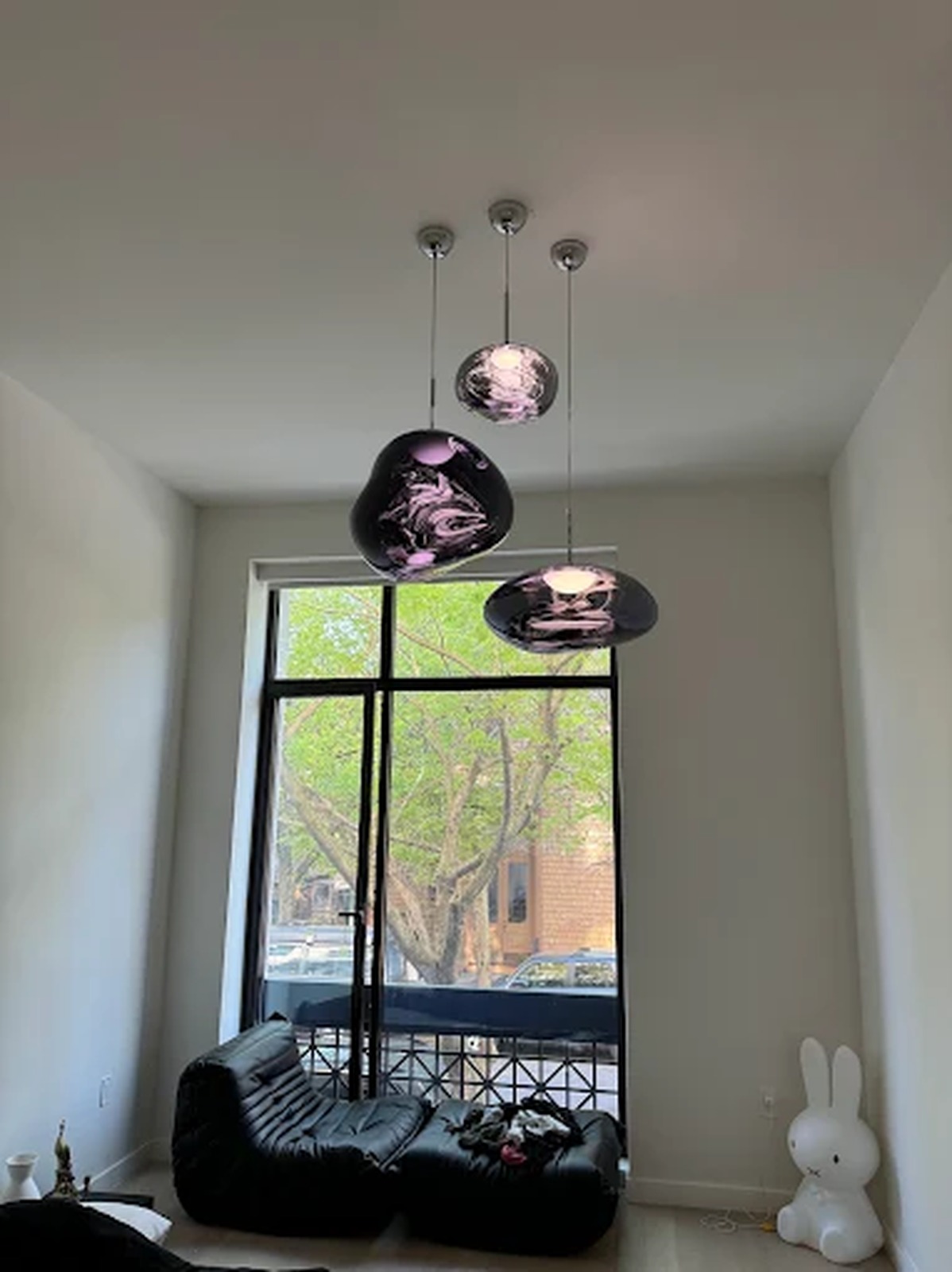 Cluster of glass pendant lights installed in a double-height living room