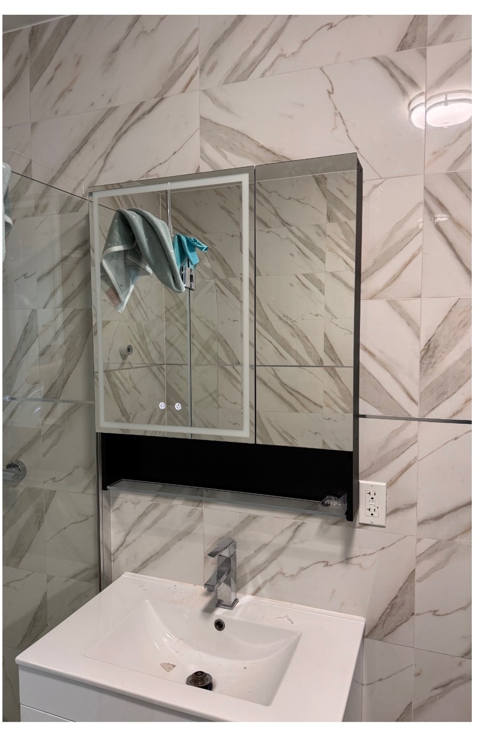 Lighted LED mirror cabinet mounted and wired above a bathroom vanity