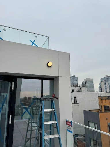 Exterior LED sconce installed on a rooftop terrace bulkhead