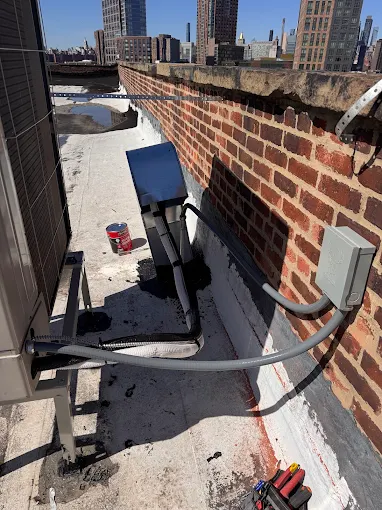 Rooftop HVAC unit feeder conduit and disconnect installed on a Manhattan roof