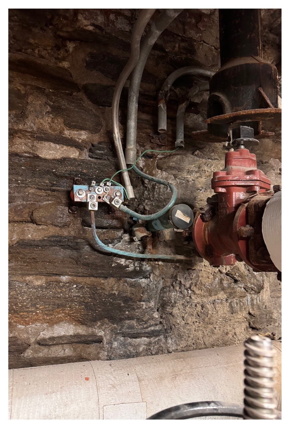 Existing corroded water main grounding connection before upgrade