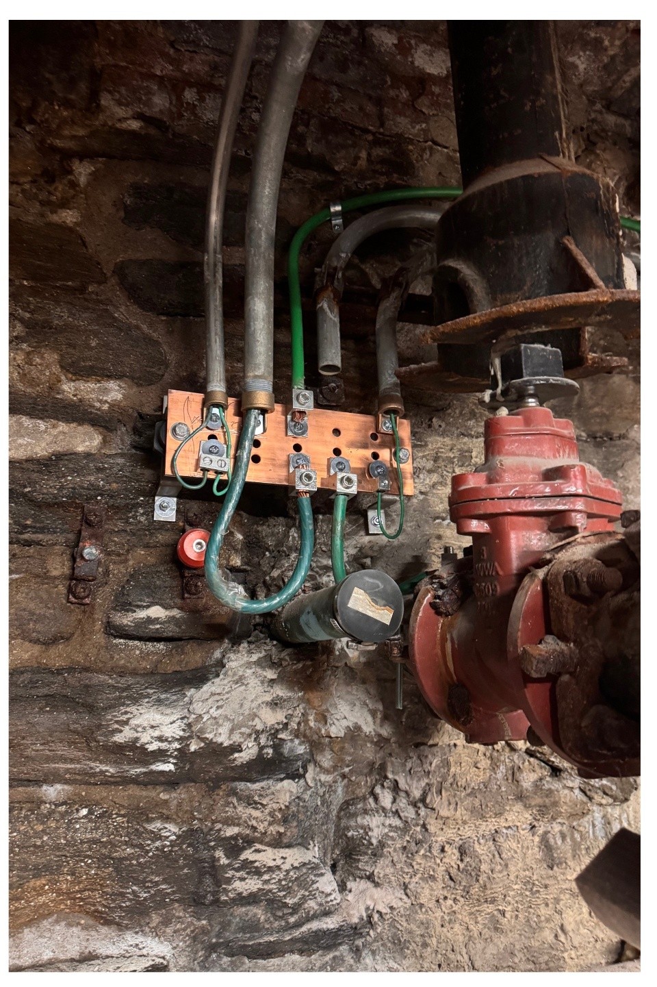 New copper ground bar with bonded grounding conductors installed on the water main