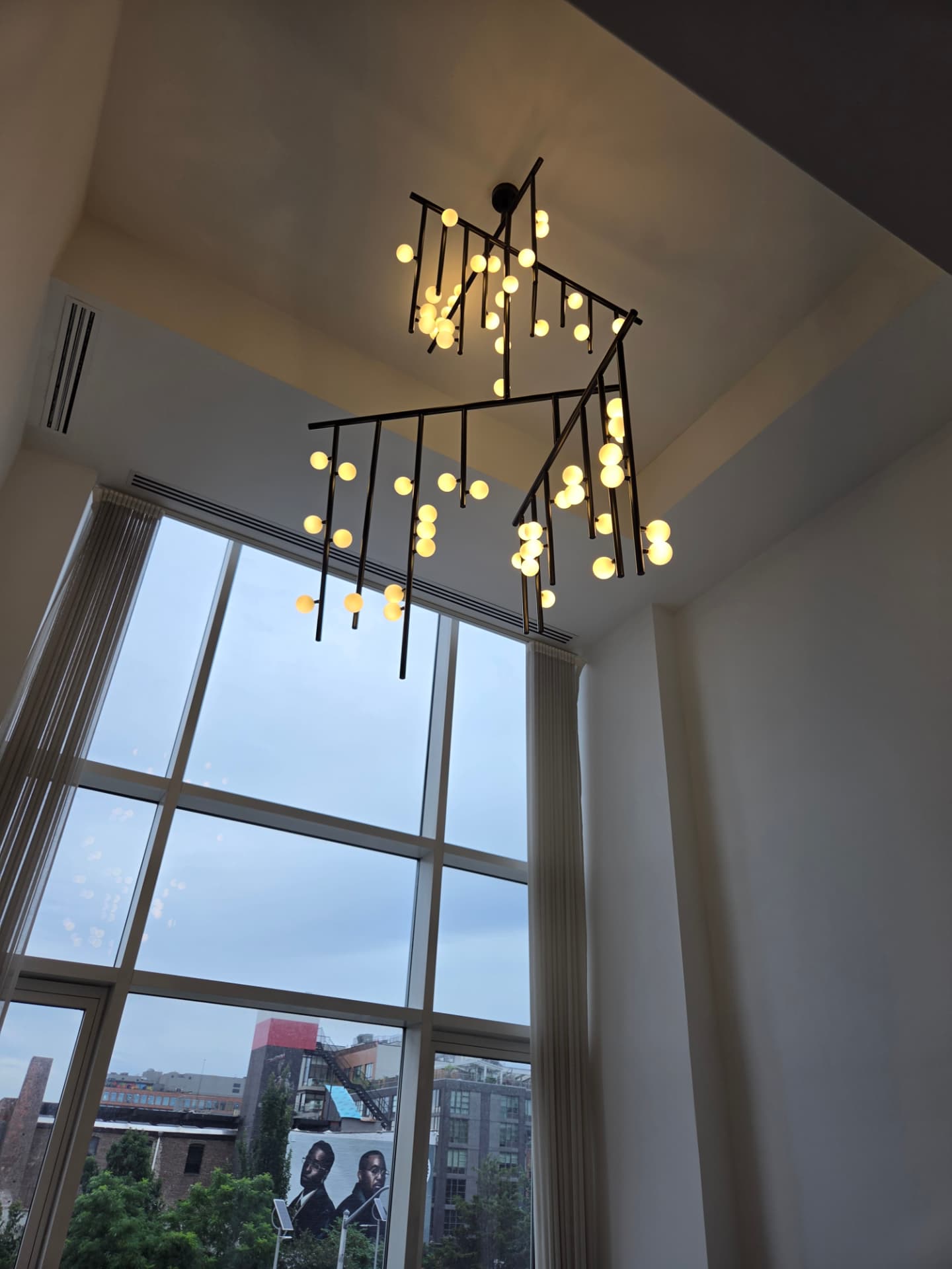 Modern statement chandelier installed in a double-height loft