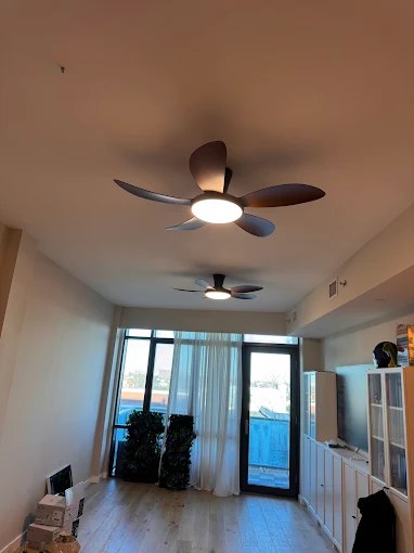 Two modern ceiling fans with lights installed in a condo living room